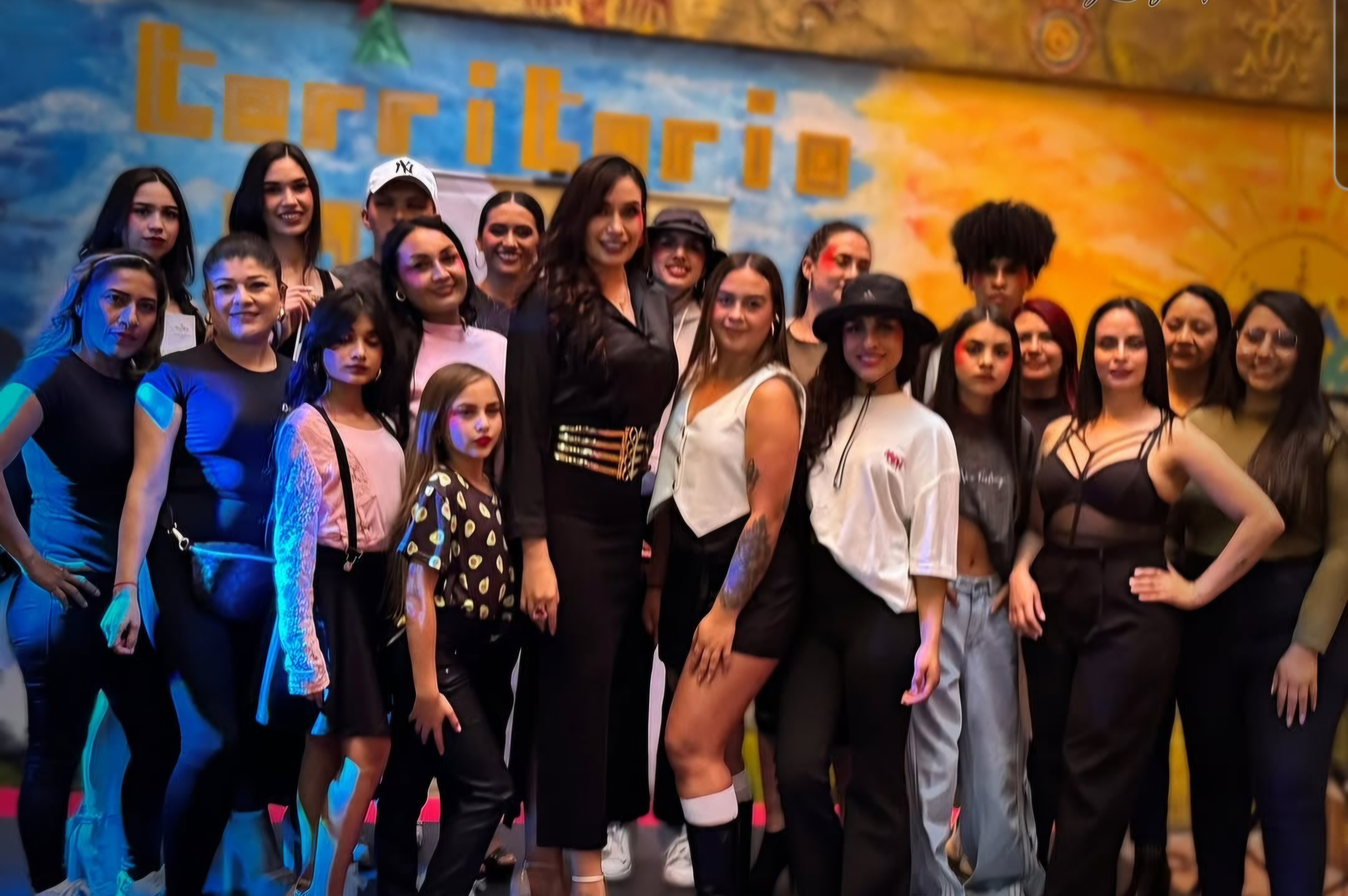 Gran grupo de modelos y participantes en escenario