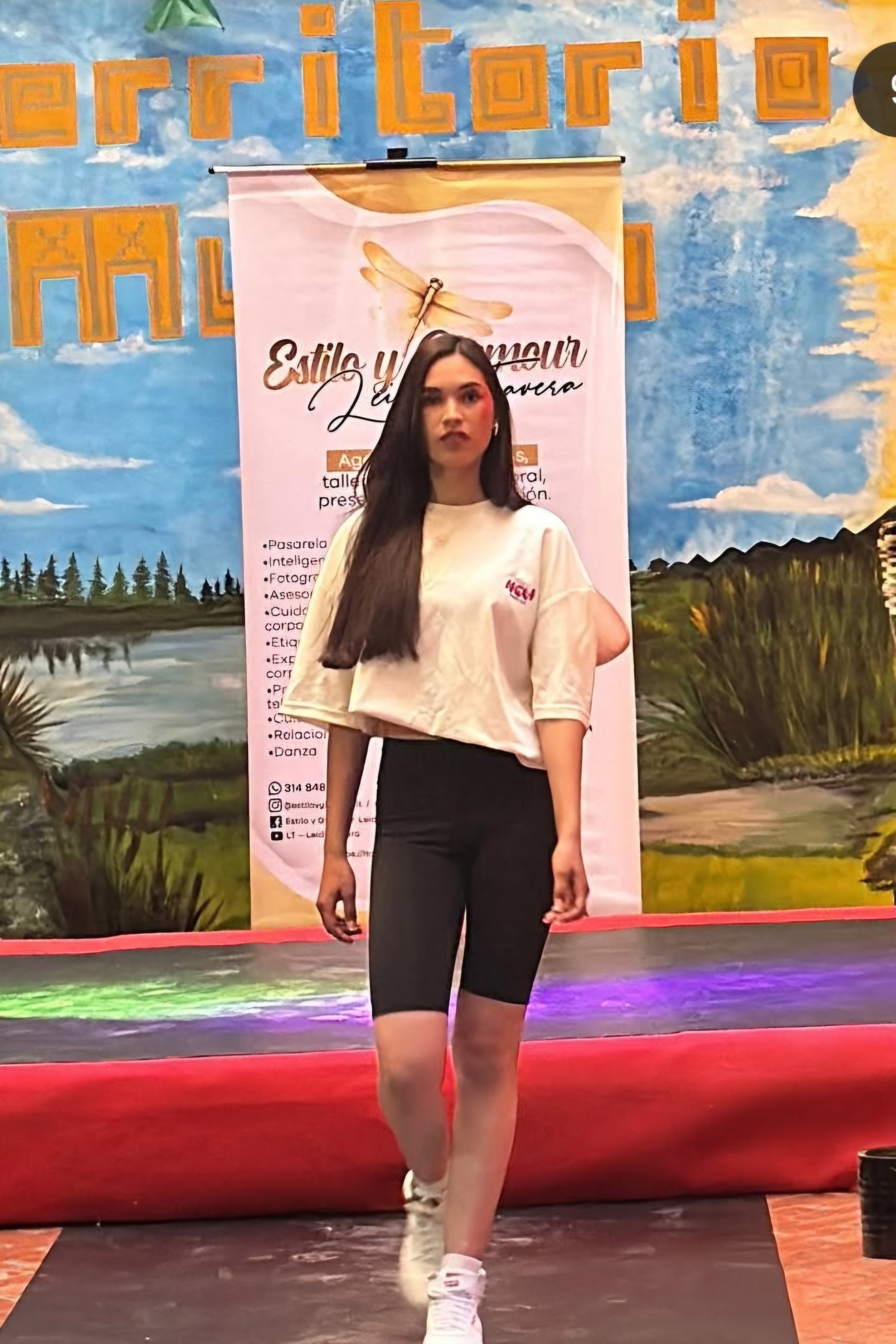 Modelo caminando en pasarela con fondo artístico